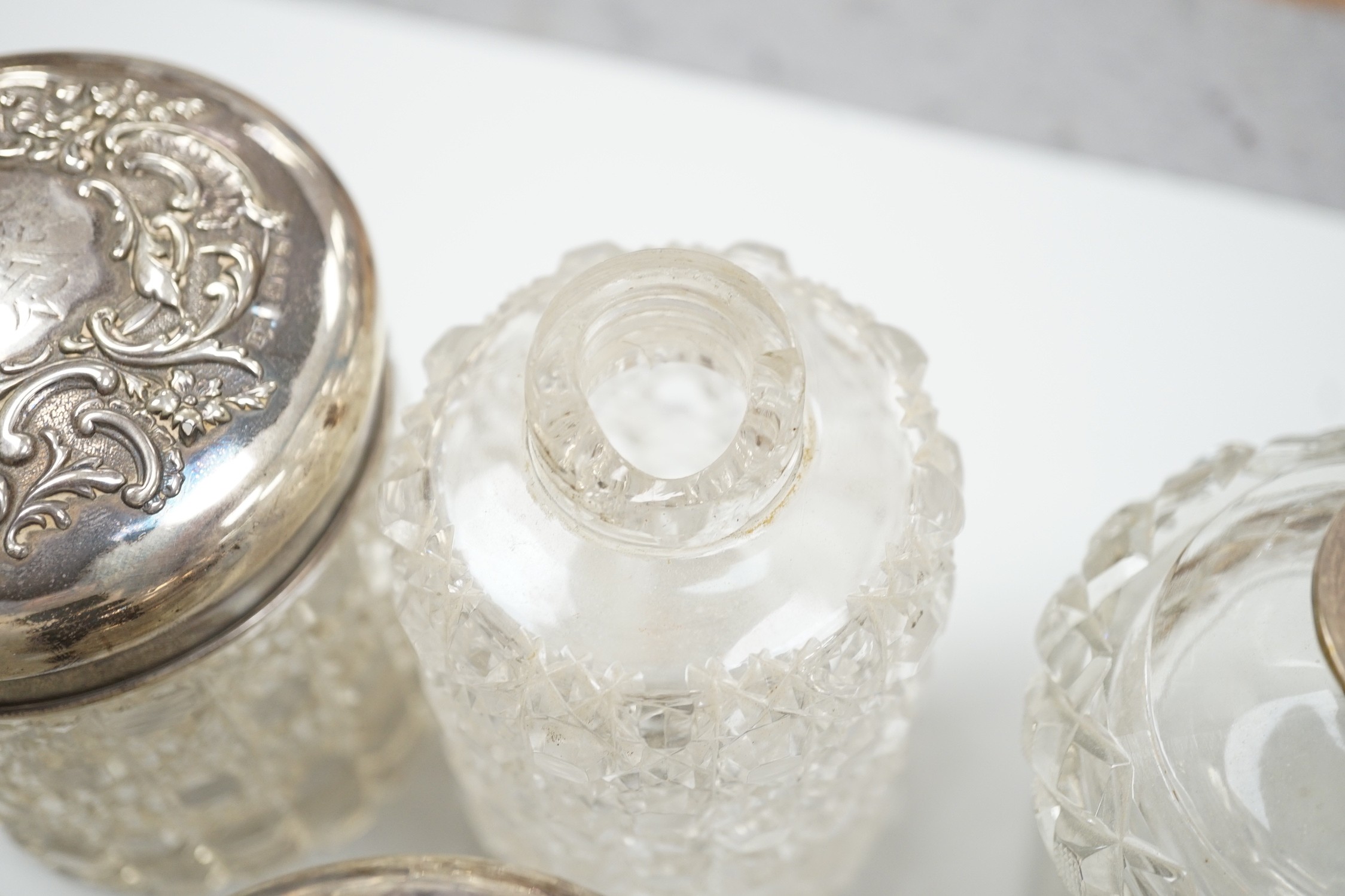 A collection of fourteen assorted late 19th/early 20th century silver mounted cut glass toilet jars or scent bottles, largest 15.5cm, some a.f.